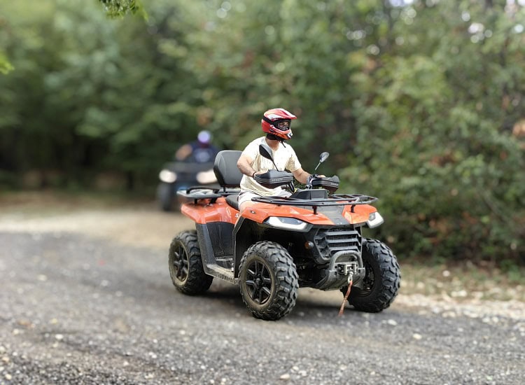 Патриотично ATV в гората с човек в защитна каска, приключенски тур на Hillview Bulgaria.