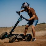 Окачена тротинетка и мъж с каска и шорти на открито.